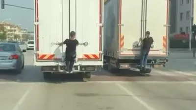 Bursa’da seyir halindeki kamyonların arkasına tutunarak yolculuk yapan gençler, hem
